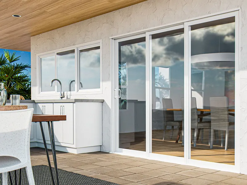 White multi-slide patio door next to an outdoor kitchen counter with bar stools