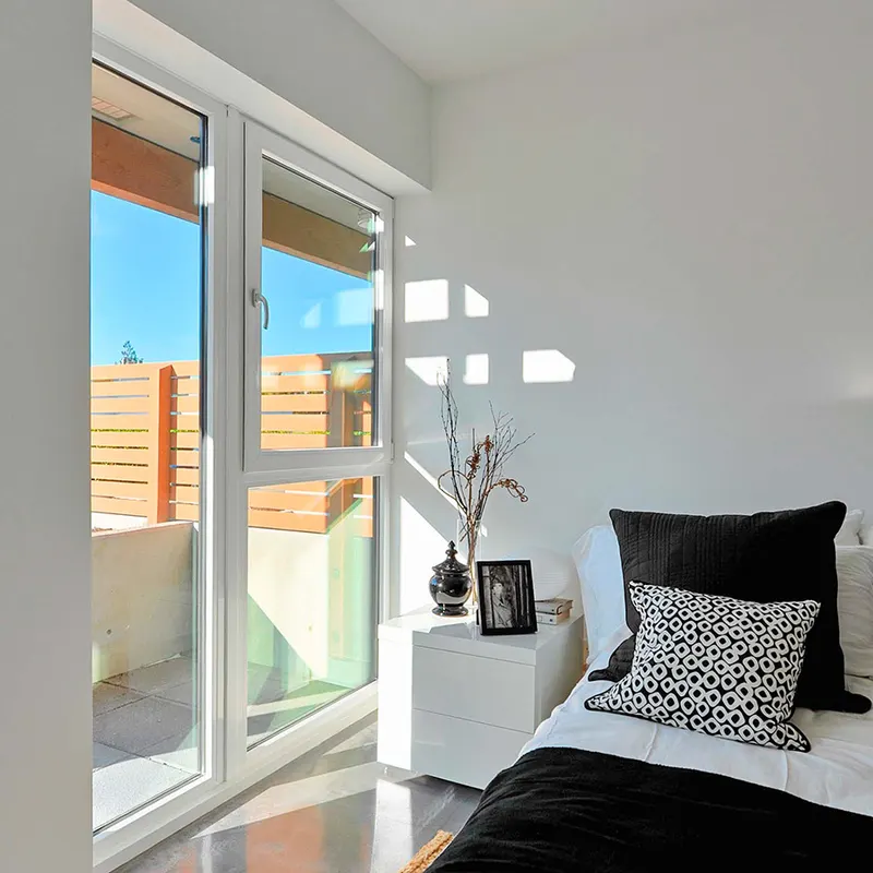 Bedroom with a white-framed French door and side window opening to a terrace