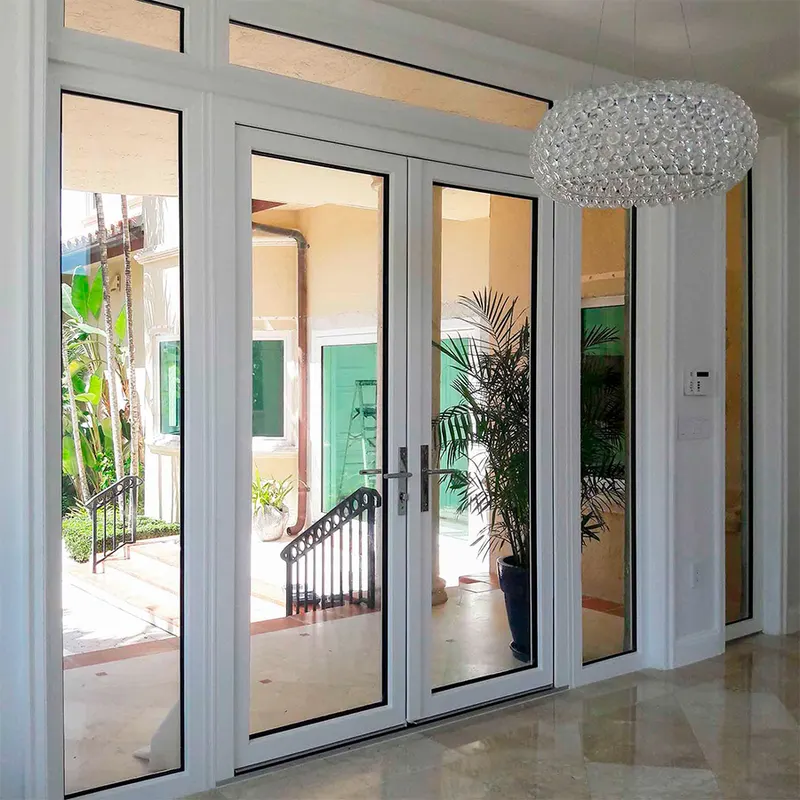 Interior foyer with tall white French doors and sidelites