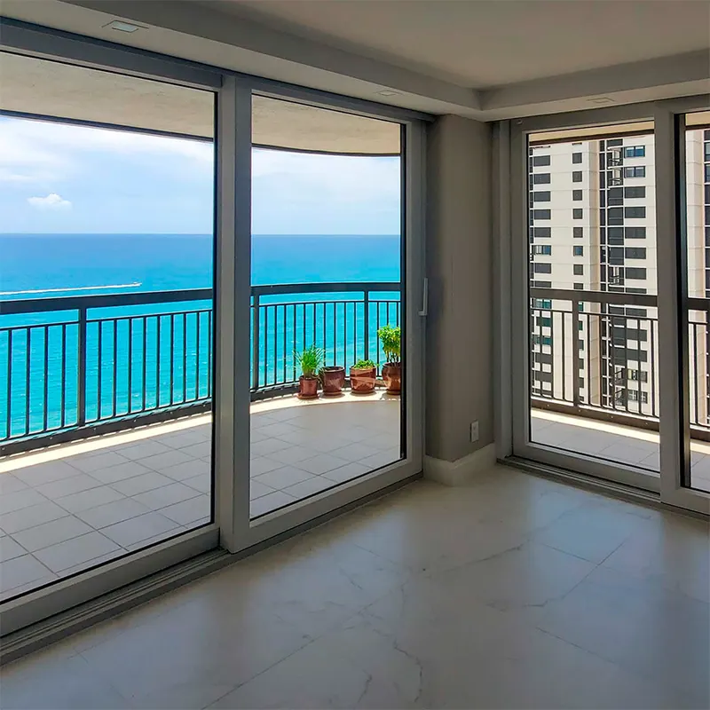 Corner living space with sliding glass doors to a balcony overlooking the ocean