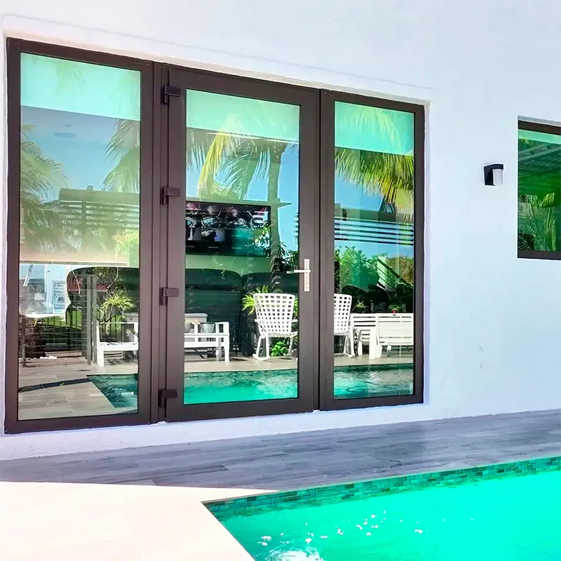 Dark-framed sliding glass doors opening onto a pool deck