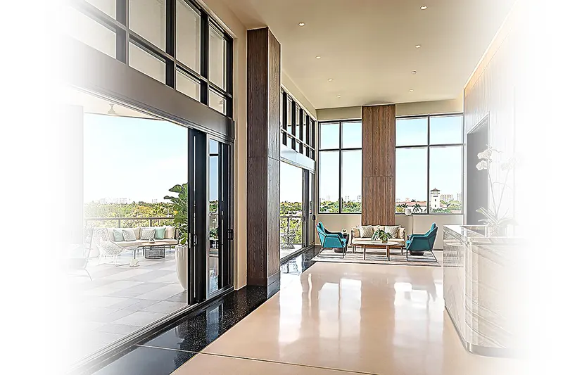 Open interior with a polished floor and a wall of tall multi-panel sliding glass doors facing a terrace