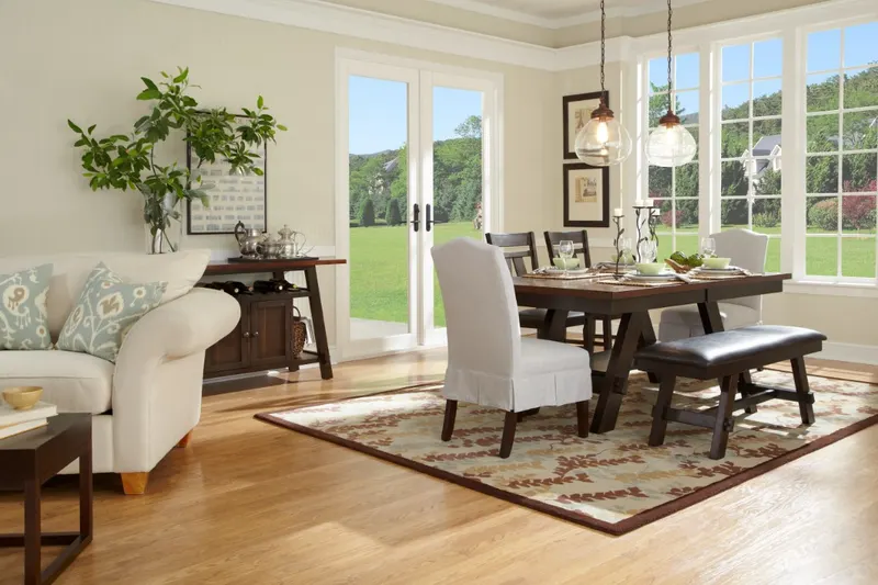 Dining room with white French doors and windows overlooking green hills
